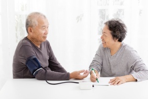 Health Advocate Checking Blood Pressure of Senior Man